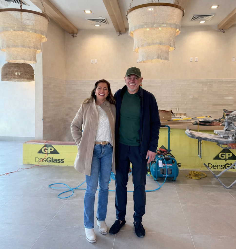 Aubergine Kitchen founders standing inside the new Sugar House restaurant location in Salt Lake City during renovation, showcasing the brand’s clean, modern interior.