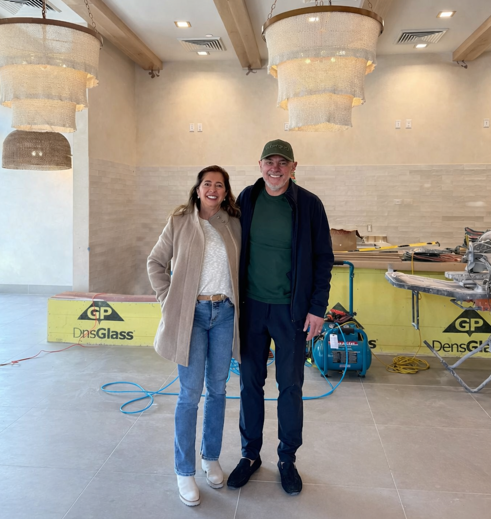 Aubergine Kitchen founders standing inside the new Sugar House restaurant location in Salt Lake City during renovation, showcasing the brand’s clean, modern interior.
